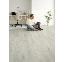 Svetlá miestnosť s laminátovou podlahou, muž a pes sedia na podlahe