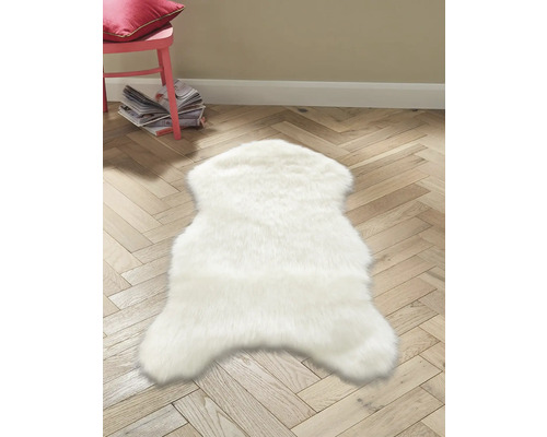Biely koberec v tvare zvieraťa na drevenej podlahe