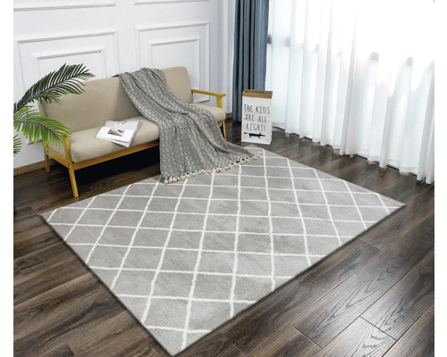 Obývacia izba s kobercom s kosoštvorcovým vzorom, pohovkou a závesmi