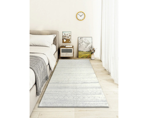 Spálňa s posteľou, nočným stolíkom, dekoráciou a svetlým kobercom so vzorom.