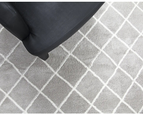 Koberec s kosoštvorcovým vzorom vedľa kresla