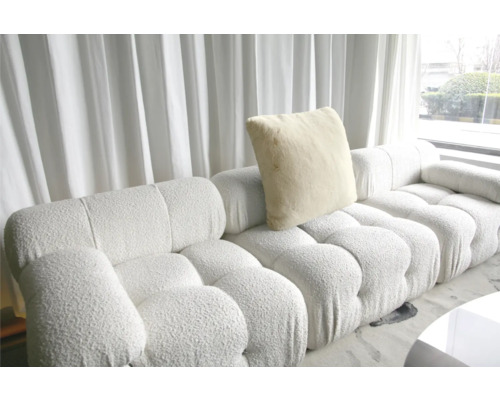 Modulárna pohovka s vankúšom pred oknom so závesmi