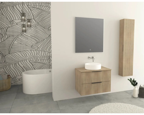 Kúpeľňa s umývadlom, zrkadlom, vysokou skriňou a vaňou pred tapetou so vzorom listov