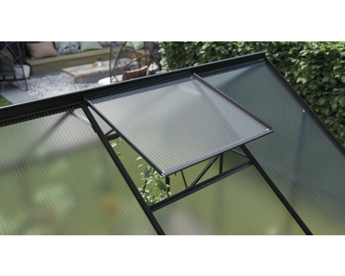 Detailný pohľad na skleník s otvoreným oknom na vetranie.