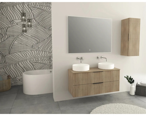 Kúpeľňa s dvojitým umývadlom, zrkadlom, závesnou skrinkou a vaňou pred tapetou s motívom listov