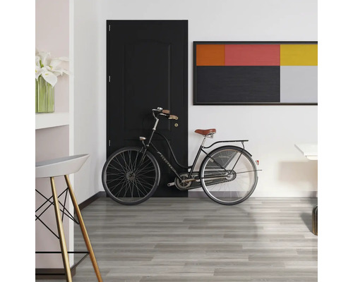 Interiér s čiernymi dverami, bicyklom a sivou drevenou podlahou