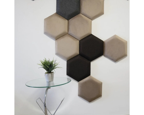 Dekoratívne šesťhranné nástenné panely v rôznych farbách na stene, vedľa malého stolíka s rastlinou.