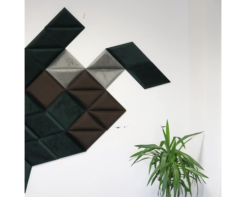 Nástenné panely trojuholníkového tvaru v rôznych odtieňoch na stene, vedľa nich izbová rastlina.