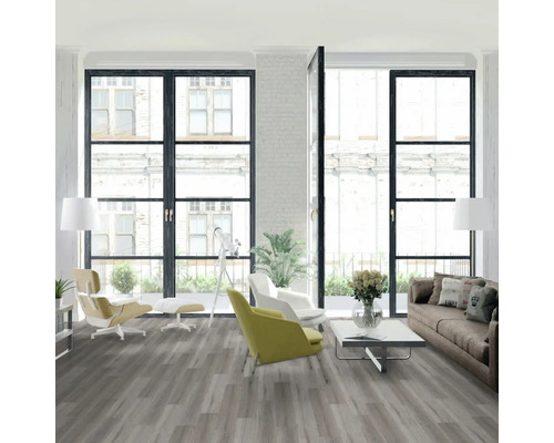 Svetlá obývacia izba so sivou podlahou, pohovkou a kreslami pred veľkými oknami