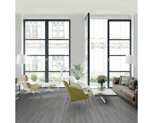 Svetlá obývacia izba so sivou podlahou, pohovkou, kreslami a oknami