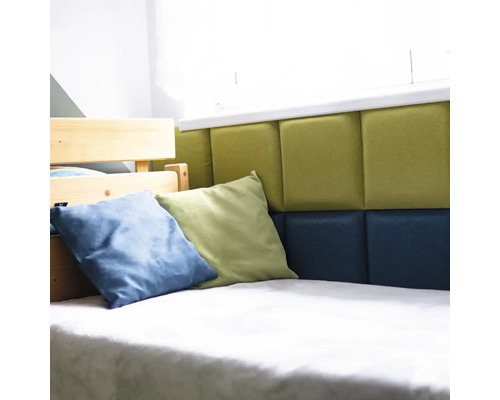 Detailný pohľad na posteľ s čalúneným čelom, zdobenú vankúšmi