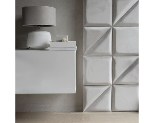 Scéna s bielou závesnou skrinkou, lampou a obkladom stien z textilných panelov