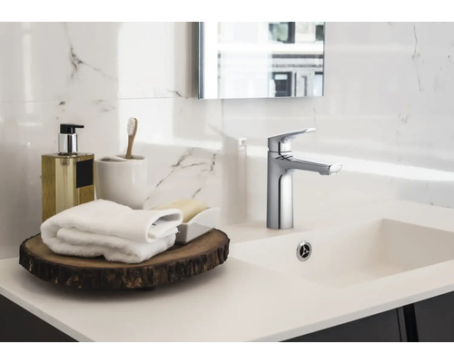 Umývadlo v kúpeľni s batériou, uteráky a kúpeľňové doplnky