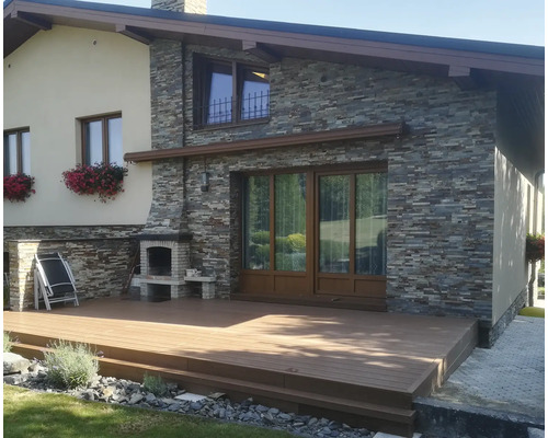 Pohľad na dom s terasou, kamennou fasádou a murovaným vonkajším grilom