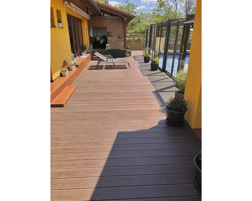 Terasa so svetlohnedými a tmavohnedými terasovými doskami, ležadlo a rastliny