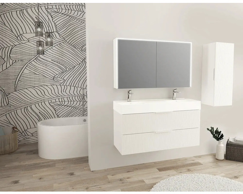 Moderná kúpeľňa s umývadlom, zrkadlovou skrinkou, vysokou skrinkou a vaňou pred stenou so vzorom listov