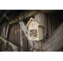 Drevený hmyzí hotel s bambusovými rúrkami na drevenom stĺpiku