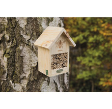 Drevený hmyzí hotel na kmeni stromu s rúrkami ako hniezdisko