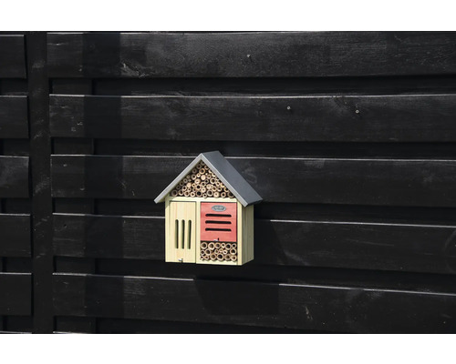 Drevený hmyzí hotel na tmavej drevenej stene