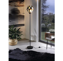 Stojacia lampa v obývacej izbe s geometrickým tienidlom.
