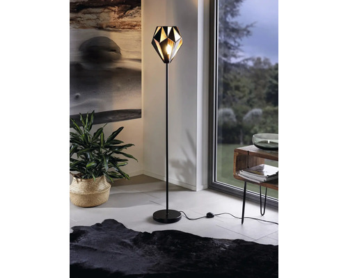 Stojacia lampa v obývacej izbe s geometrickým tienidlom.