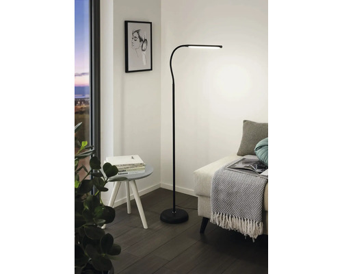 Moderná stojacia lampa v obývacej izbe vedľa pohovky a konferenčného stolíka