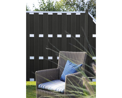 Záhrada so zástenou a prúteným kreslom s vankúšmi