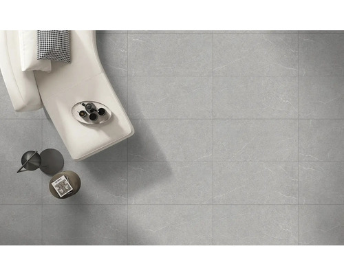 Svetlá miestnosť s podlahovými dlaždicami so vzhľadom mramoru, pohovka a dekorácie