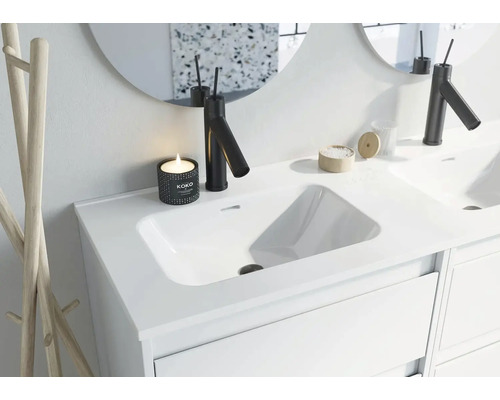 Moderné kúpeľňové umývadlo s batériou, zrkadlom a dekoráciou.