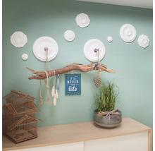 Dekoratívna nástenná dekorácia s ozdobnými lištami, vešiakom na konáre a doplnkami na komode.