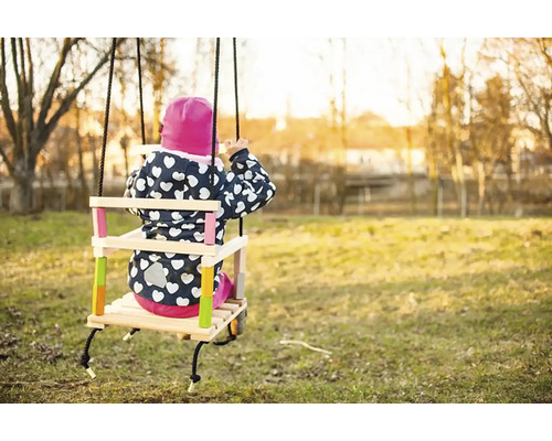 Dieťa na drevenej hojdačke v záhrade