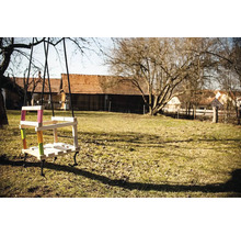 Drevená hojdačka s farebnými akcentmi v záhrade