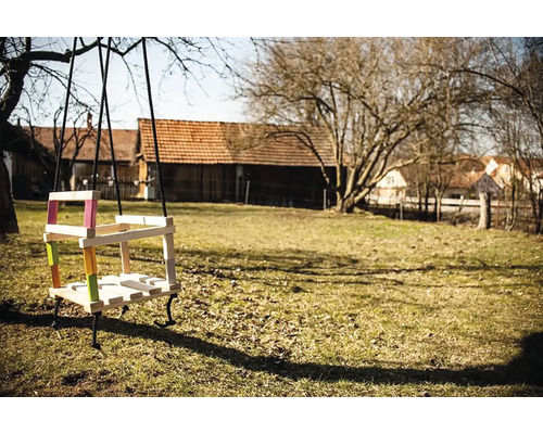 Drevená hojdačka s farebnými akcentmi v záhrade