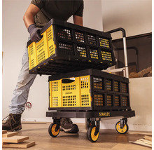 Muž prepravuje skladacie prepravky Stanley na vozíku