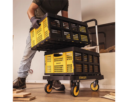 Muž prepravuje skladacie prepravky Stanley na vozíku