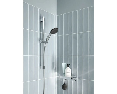 Sprchová armatúra s ručnou sprchou a sprchovou policou v kúpeľni.