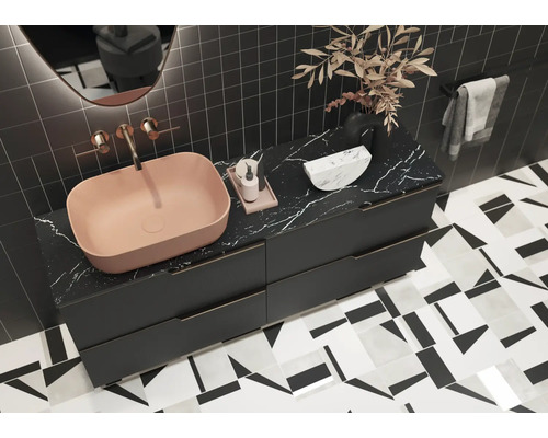 Moderná kúpeľňa s umývadlom na dosku, skrinkou pod umývadlo a geometrickými obkladmi.