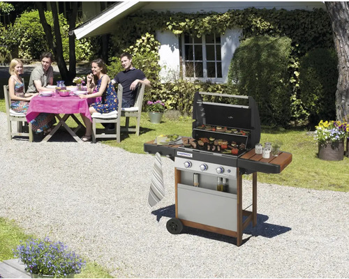 Scéna s plynovým grilom na záhrade a skupinou ľudí pri stole