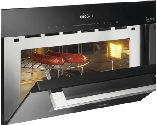 Otvorená čierna mikrovlnná rúra s dvoma klobásami na rošte.