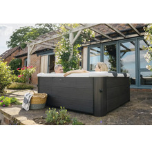 Vstavaná vírivka v záhrade s dvoma ľuďmi vo vode, košom a dekou