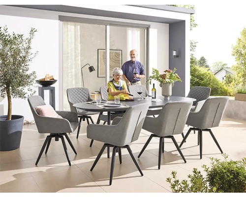 Veľká terasa so zaobleným kamenným jedálenským stolom obklopeným ôsmimi stoličkami s podrúčkami