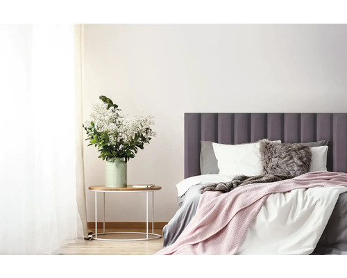 Svetlá spálňa s posteľou, nočným stolíkom a kvetmi