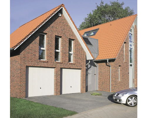 Pohľad na dom s dvoma garážovými bránami, tehlovou fasádou a škridlovou strechou