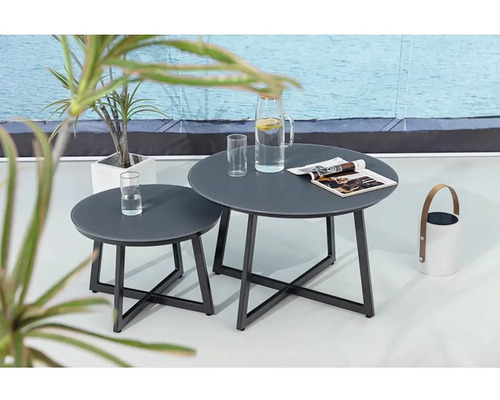 Dva kovové konferenčné stolíky s okrúhlymi doskami na terase s nápojmi a časopisom