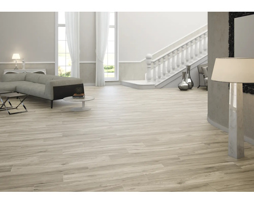 Svetlá obývacia izba s pohovkou, schodiskom a dlaždicami s dreveným dekorom