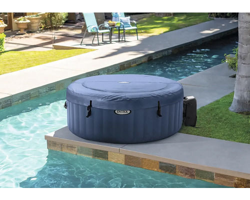 Nafukovacia okrúhla vírivka Intex vedľa bazéna v záhrade.