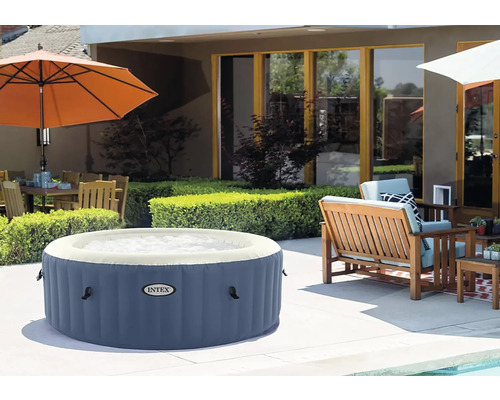 Nafukovacia vírivka v záhrade so sedením a slnečníkom.