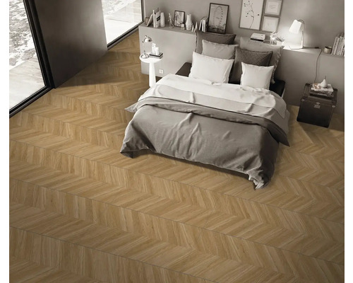 Spálňa s parketovou podlahou so vzorom rybej kosti, posteľou a minimalistickou výzdobou.