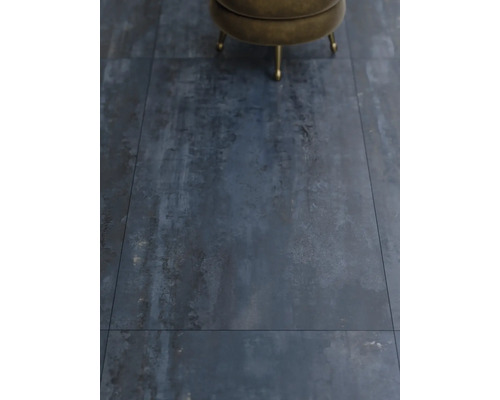 Detailný záber na podlahové dlaždice s industriálnym dizajnom a stoličkou