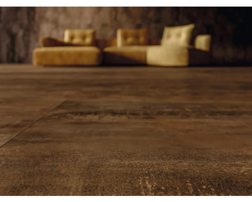 Detail tmavej hnedej podlahovej krytiny s pohovkou v pozadí